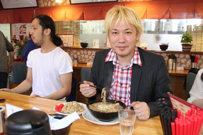 市内ラーメン店で背脂ラーメンを食べる津田さん
