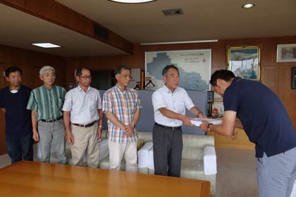 国定三条市長(右)に善意31万円余りを手渡す三条クラフトフェア実行委員会の高橋委員長ら