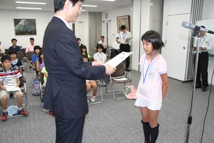 子ども記者の任命式で任命書を手渡す鈴木市長