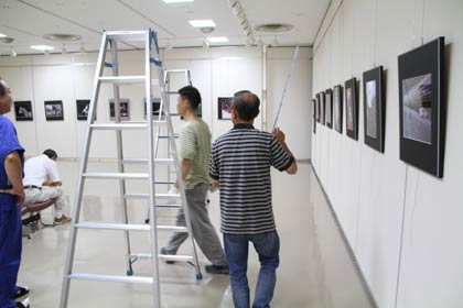 13、14の2日間、燕市文化会館展示ホールで開かれる「第16回PHOTO風音写真展」に向けて12日夜、会場で展示作業を行うPHOTO風音の会員