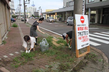 吉田まつり前日の25日夕方、まつり会場となる通りの雑草をとるボランティアを行う旭町1丁目商店街の人たち