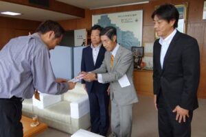 金婚式を記念してカーブミラー設置に役立ててほしいと三条市に30万円を寄付した加藤紋次郎さん、左から国定市長、小林三条署長、加藤さん、長男益朗さん