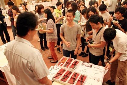 「プレ工場の祭典」の企業と学生の意見交換交流会、一言PRタイムで各社のコーナーを囲む芸大生