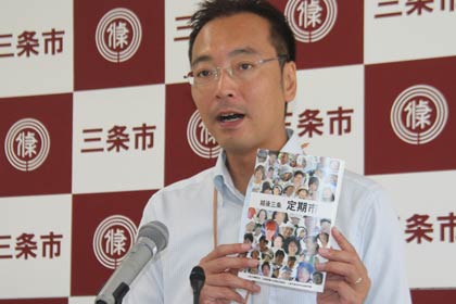6日の定例記者会見で情報誌『越後三条　定期市』の完成について話す国定市長