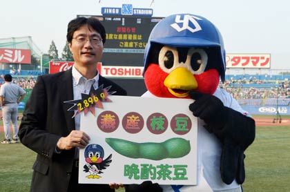 ギャランティーの「晩酌枝豆」の目録を手に鈴木市長とつば九郎