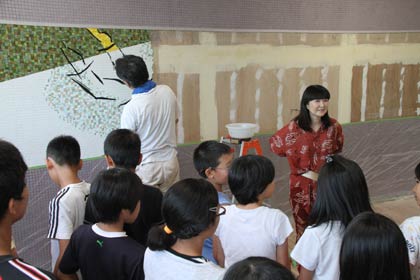 29、30日と燕市立吉田小学校図書室で創立140周年記念の壁画の最後の仕上げ、原画を描いた壁画家、松井エイコさんが立ち会い、作業のようすは児童にも公開