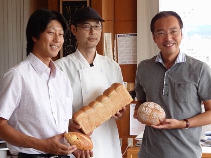 三条産小麦で作ったパンを手に左から燕三条イタリア野菜研究会の内山会長、「サン・フォーレット」の磯辺さん、国定市長