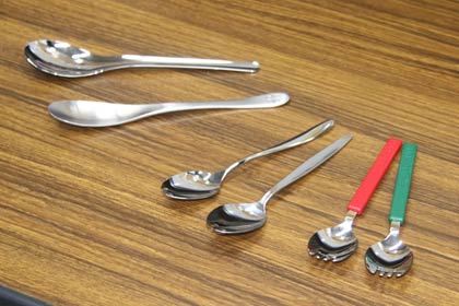 左から来場者1日先着1,000人にプレゼントする2種類のスプーン、スタンプラリーの賞品の2種類の先割れスプーン、シャトルバス利用者1日先着1,000人にプレゼントする先割れスプーン