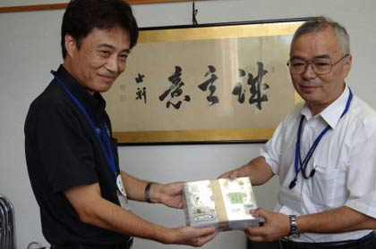 JA新潟三条市店の五十嵐支店長が四日町小の小野島校長に「キラッとシール」を手渡す