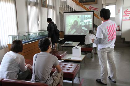 山崎金属工業の入り口で洋食器の製造工程を収録した映像を見学