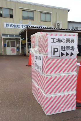 セブン・セブンの前には工場の祭典の開催を知らせるピンクのストライブの段ボール箱