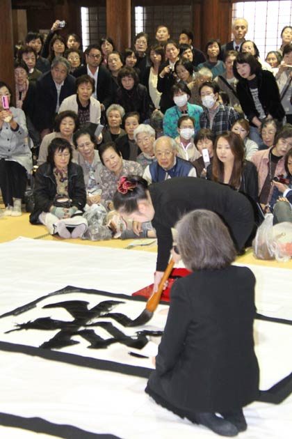 畳ほどもある大きな紙に“慈”と“愛”を書く