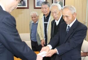 鈴木市長に10万円の寄付を手渡す燕社交ダンス踏友会の長谷川会長(いちばん右