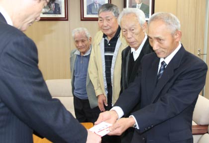鈴木市長に10万円の寄付を手渡す燕社交ダンス踏友会の長谷川会長（いちばん右