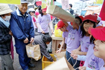 二七の市に出店して自分たちで栽培したサツマイモを販売する三条市立飯田小学校3年生