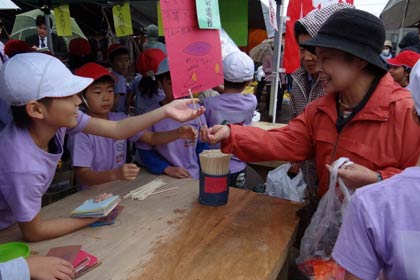  二七の市に出店して自分たちで栽培したサツマイモを販売する三条市立飯田小学校3年生