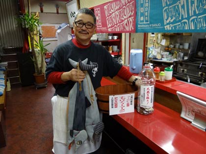 龍昇園の刈屋店主とすでに善意が寄せられ始めているペットボトルの募金箱