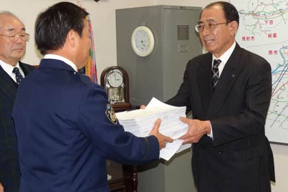 小林三条署長に会員事業所352社12,589人の署名簿を提出する三条市交通安全協会安全運転管理者部会の金川部会長
