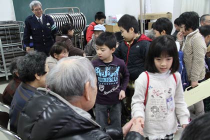 お年寄りと握手して帰る粟生津小2年生
