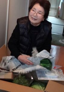 兵庫県豊岡市から届いた正月用品などのプレゼントを受け取った福島県南相馬市小高区から三条市内に避難している松崎さん