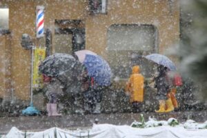 燕市米納津で降りしきる雪のなか下校する小学生
