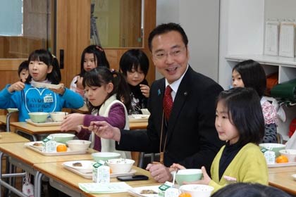 一ノ木戸小2年1組の「目指せ！食べ方名人」で児童と席を並べて和食の作法を学び、給食を味わう国定市長