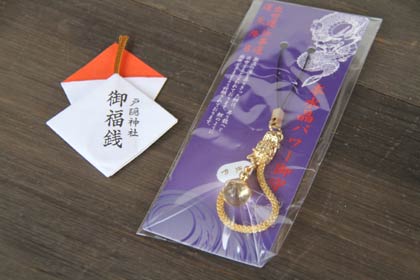 歳旦祭後に先着500人に無料配布する御福銭(左)と戸隠神社の神使、龍神をデザインして本翡翠も使われた人気のストラップ