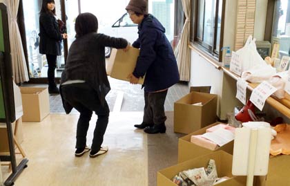 おせち料理の入った段ボール箱を持って配達に出発