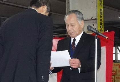 国定市長に向かって寄付の目録を読み上げる中央青果市場の青柳社長