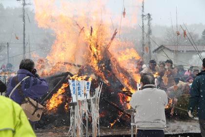 燃え盛る塞の神の火でするめを焼く