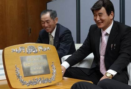 内閣総理大臣表彰の盾を前に国定市長と歓談