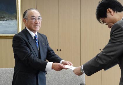 鈴木市長に卓球台2台の寄付の目録を手渡す田中さん