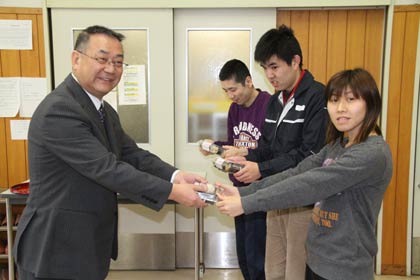 障害者支援施設「つばくろの里」と就労継続支援B型「夢工場つばめ」の利用者代表に寄付の恵方巻を手渡すローソン燕杣木店の長岡オーナー(左)