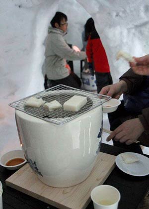かまくらの中でもちを焼く