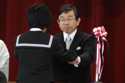 卒業生に「おめでとう」と声をかけて卒業証書を手渡す西山校長