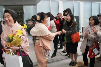  時間外出入り口から最後の退庁をする退職者を見送る