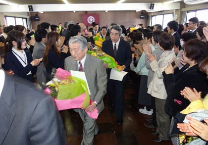 花束を手に退場する職員