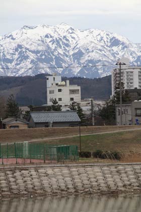 三条市の瑞雲橋たもとから望む県境の粟ヶ岳は残雪がまだらに