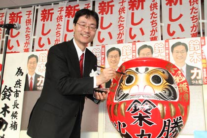 燕市長選に無投票で再選され、だるまに目を入れる現職の鈴木力氏