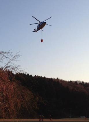 バケットを取り付けて槻の森公園を飛び立つ防災ヘリ