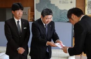 国定三条市長(右)にカーブミラー5基の目録を手渡す三条信用金庫の西潟理事長(中)と浅見幹事長(左)