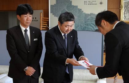  国定三条市長(右)にカーブミラー5基の目録を手渡す三条信用金庫の西潟理事長(中)と浅見幹事長(左)
