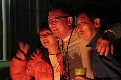 スノーピークファンと一緒に記念写真に写る山井社長(中央)