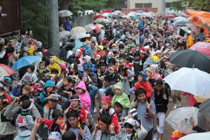 舞い込みは雨のなか雨具などを着て親が子どもを肩車して境内を走る