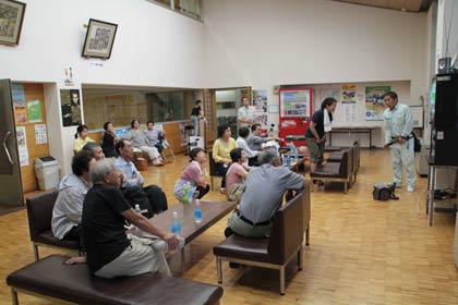 ロビーで大雨に関するニュースに見入る