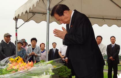 献花して手を合わせる太田国交相