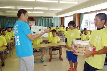 只見高校生徒からプレゼントのトマトを受け取る国定三条市長