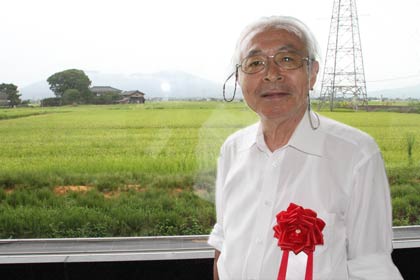 八木澤名教授がイメージした田園と弥彦山が広がる窓の外の原風景を背に