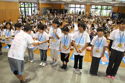 嘉瀬団長から74人全員に完歩賞を手渡す