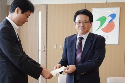 鈴木燕市長に社内イベントで販売した商品の売り上げ53万7,900円を手渡すサーモス新潟事業所の山田所長